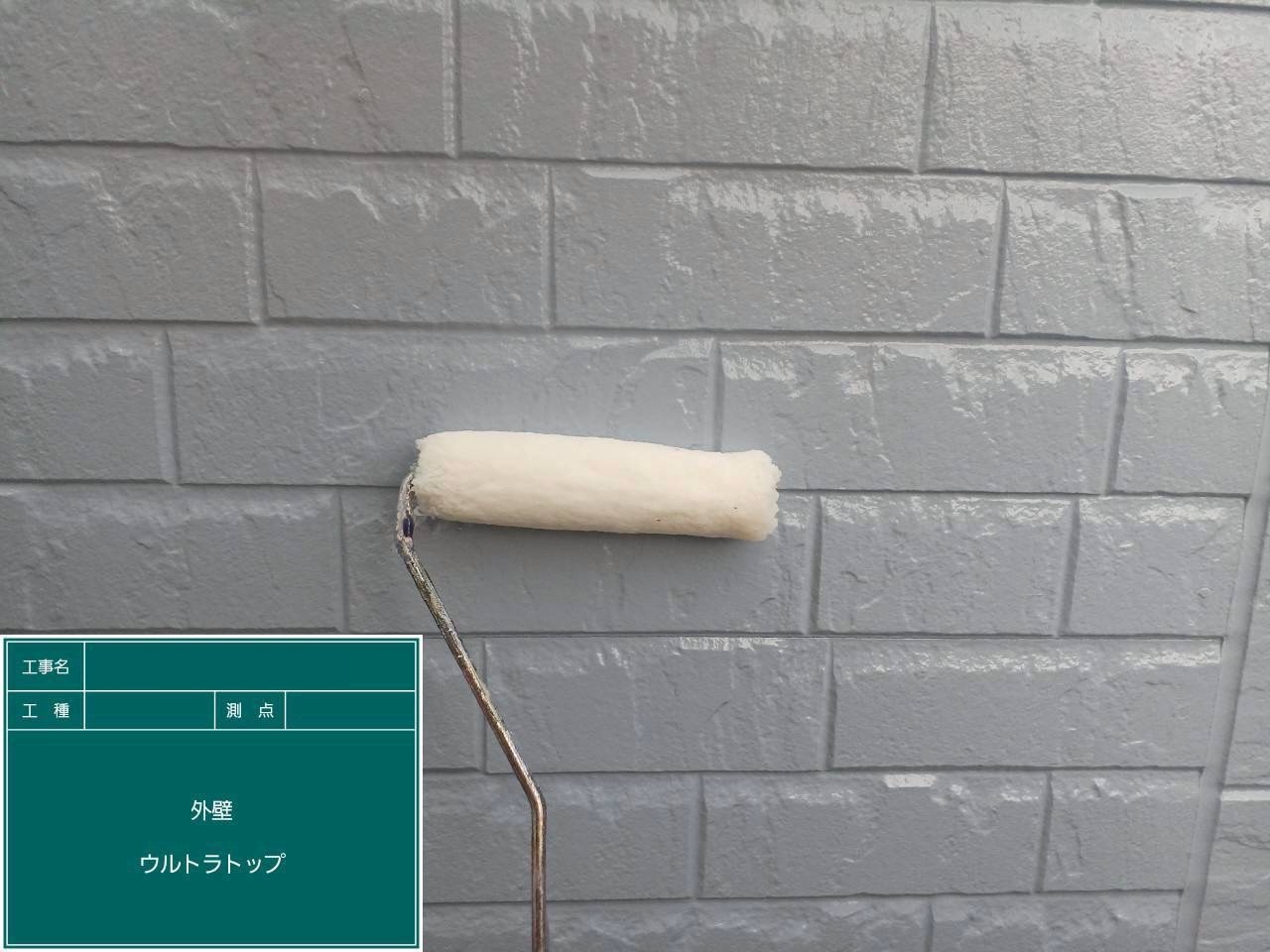 上塗りが完了したサイディングにウルトラトップを施工中